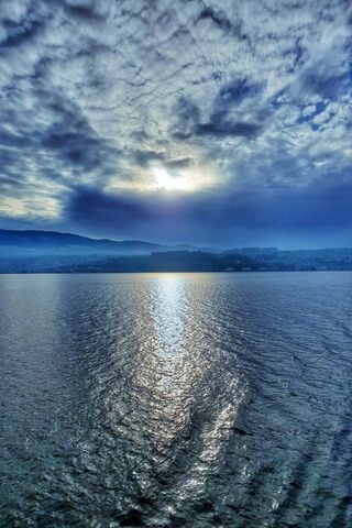 Serenity Over Water: A Dance of Hills and Clouds 🌅🌊
